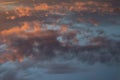 Dramatic sky with golden, purple and orange fluffy clouds and soft sun beams as abstract background, texture.