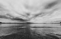 Dramatic sky over beautiful calm water in Gulf of Bothnia. Storsand, High Coast in northern Sweden. Black and white moody image Royalty Free Stock Photo