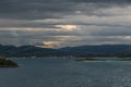 Dramatic sky over beautiful seascape. A village on coastline. Sunrays peaking through clouds. Royalty Free Stock Photo