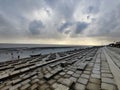 Dramatic sky over the pier at low tide in the evening Royalty Free Stock Photo