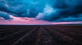 Dramatic Sky Over Plowed Field at Dusk with Vibrant Colors and Textured Soil Patterns Royalty Free Stock Photo