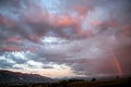 Dramatic sky panorama at sunset. Fire red clouds over the mountains and rainbow Royalty Free Stock Photo