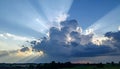 Dramatic Sky with Sunlight Rays Piercing Through Clouds Over Rural Landscape at Dusk Royalty Free Stock Photo
