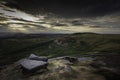 Dramatic sky at sunset over hills with rocks and fields Royalty Free Stock Photo