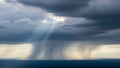 Dramatic Sky with Sunbeams Breaking Through Dark Storm Clouds Over Water rain Royalty Free Stock Photo