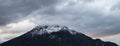 Dramatic snowy peak lonely mountain panorama landscape scenic moody view with cloudy gray sky background, copy space Royalty Free Stock Photo