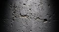 Dramatic Spotlit Texture of Grey Concrete with Rough Surface and Visible Cracks Casting Deep Shadows for Impactful Visuals Royalty Free Stock Photo