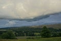 Storm clouds gather over lush farmland in the Highlands of Scotland