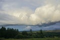 Storm clouds gather over lush farmland in the Highlands of Scotland.