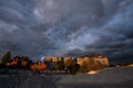 Dramatic storm clouds over the rooftops at summer sunset Royalty Free Stock Photo