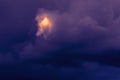 Dramatic Storm Clouds with a Shining Golden Spot. Light in the Darkness, Flash in the Night Concept Royalty Free Stock Photo