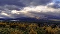 Dramatic storm sky landscape with sun rays between the clouds and over the mountains. Dark landscape Royalty Free Stock Photo