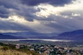 Dramatic storm sky landscape with sun rays between the clouds and over the mountains. Dark landscape Royalty Free Stock Photo