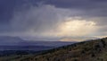 Dramatic storm sky landscape with sun rays between the clouds and over the mountains. Dark landscape Royalty Free Stock Photo