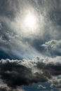 dramatic stormy sky with a blurred sun disk and heavy cumulus clouds against a dense cloud cover. artwork picture for fantasy, Royalty Free Stock Photo