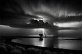 Dramatic stormy sky with lightning over a lake, black and white
