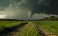 Dramatic stormy sky over a green field and dirt road Royalty Free Stock Photo