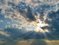 Dramatic stormy sunset sky with sun rays breaking through gloomy clouds. Royalty Free Stock Photo