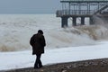 Dramatic, stormy weather, lonely old man walking along coast Royalty Free Stock Photo