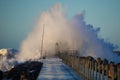 Dramatic, strong waves and foam spray hit the pier in Vorupoer on the North Sea coast of Denmark Royalty Free Stock Photo
