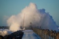 Dramatic, strong waves and foam spray hit the pier in Vorupoer on the North Sea coast of Denmark Royalty Free Stock Photo