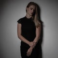 Dramatic studio portrait of beautiful young woman on dark background