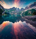 Dramatic summer sunset on unique lake - Oeschinen Oeschinensee, UNESCO World Heritage Site. Red clouds reflected in the calm sur Royalty Free Stock Photo