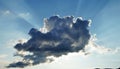 Dramatic sun rays breaking through a dark cloud in the blue sky. Royalty Free Stock Photo