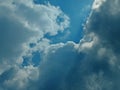 Dramatic Sun Rays Breaking Through Dark Clouds, Moody Sky with Blue Patches and White Clouds, Beautiful Cloudscape Royalty Free Stock Photo