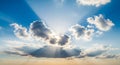Dramatic sun rays bursting through blue sky clouds Royalty Free Stock Photo
