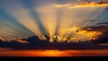 Dramatic sun rays bursting through dark clouds at sunset Royalty Free Stock Photo