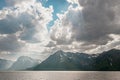 Dramatic sunbeams, clouds, and snowcapped mountains over Jackson Lake in Grand Teton National Park