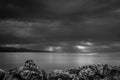 Dramatic sunburst through heavy stormy hurricane rain clouds beyond the coastline mountains.