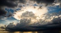 Dramatic sunlight piercing through dark storm clouds in a sky Royalty Free Stock Photo