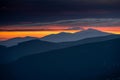 Dramatic sunrise in Beskids Mountains. View from Rysianka mountain to Babia Gora peak on the fire red sky