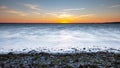 dramatic sunrise over the baltic sea with rocky beach and trees Royalty Free Stock Photo