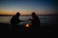 dramatic sunrise over the baltic sea with rocky beach and two pe Royalty Free Stock Photo