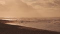 Dramatic sunrise over the ocean. Sandy coast of Oahu island, Hawaii. People walk along the beach. A ray of the sun Royalty Free Stock Photo