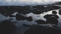 Dramatic sunset on the beach over the waters and rocks