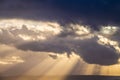 A dramatic sunset through the clouds over the ocean with rays of light Royalty Free Stock Photo