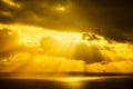 A dramatic sunset through the clouds over the ocean with rays of light Royalty Free Stock Photo