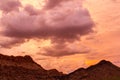 Dramatic sunset with clouds over rocky hillocks
