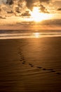 Dramatic Sunset with footsteps on a sandy beach
