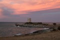 Dramatic Sunset landscape with pink sky and medieval tower, Italy.