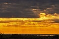 Dramatic sunset like fire in the sky with golden clouds and beams of the sun. Beautiful abstract colorful background. Selective Royalty Free Stock Photo