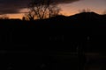 Dramatic sunset with lilac orange clouds over bar trees and hills in wintertime in Switzerland. Unprocessed and original Royalty Free Stock Photo