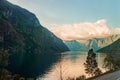 Dramatic sunset in the mountains above the fjord of Norway. Beautiful view with reflection in the water