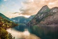 Dramatic sunset in the mountains above the fjord of Norway. Beautiful view with reflection in the water