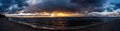 Dramatic sunset nature background. Sunset sea coast. Panoramic seascape with golden sunbeams reflected in the ocean water Royalty Free Stock Photo