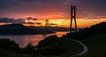Dramatic Sunset Over a Cable- Stayed Bridge and Calm Water with Lush Green Hills cable-stayed bridge Royalty Free Stock Photo